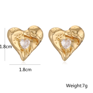 Detailed view of 1.8cm gold heart earrings with hammered texture and clear crystal center