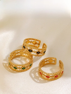 Detailed shot of three gold adjustable rings featuring vintage enamel diamond patterns