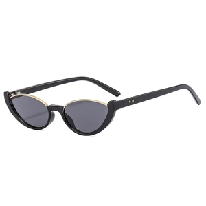 Fashionable cat-eye sunglasses with black glossy frames and gold metal trim on white background