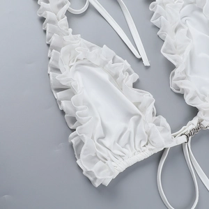 Detail of white bikini top with ruffled layers and heart-shaped metal connector