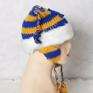 Detailed close-up of blue and yellow striped knit hat with white faux fur trim and tassels