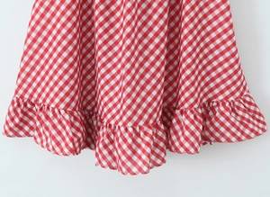 Détail de l'ourlet de robe à carreaux rouge et blanc avec bord à volants élégant