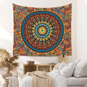 Detail of bohemian mandala tapestry in orange and blue tones on a bedroom wall