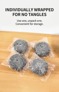 Set of four steel wool cleaning scrubbers in individual packaging on a wooden table