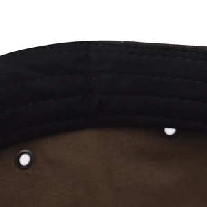 Détail de l'intérieur d'une casquette en coton avec bandeau noir et œillets métalliques