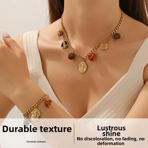 Detail of vintage gold plated chain necklace with coin pendants and resin stones