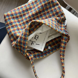 Close-up of retro houndstooth knit tote bag with silver magnetic snap and canvas lining