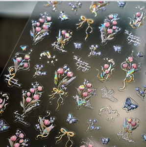 Macro shot of 3D holographic flower and bow nail stickers with rainbow light effect