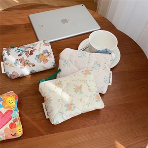 Close-up of quilted floral cotton coin purses with simple wish label on a wooden desk