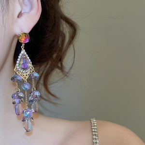 Detail of colorful crystal tassel earring on model showing sparkling multi-color rhinestones