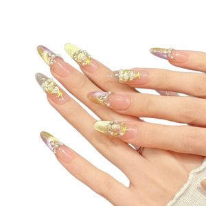Pink gradient press-on nails with pearls, crystals, and gold stars in almond shape