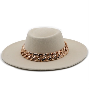 Detail of beige wool felt fedora featuring a thick gold chain link hatband decoration