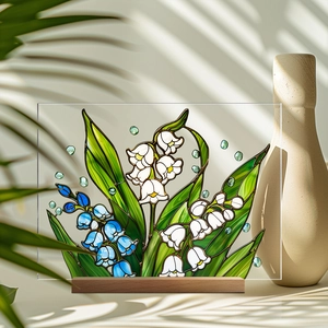 Macro detail of acrylic lily of the valley flowers on a natural wood base with leaf shadows