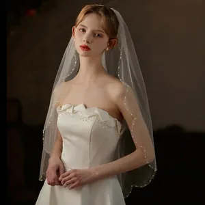 Elegant white short bridal veil with hand-sewn pearls and metal hair comb for wedding