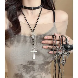 Collana gotica a strati con ciondolo a croce nera e choker in pelle con stella su modella