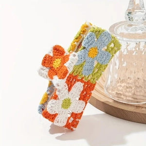 Macro view of handmade crochet floral hair claw with orange and blue knit patterns