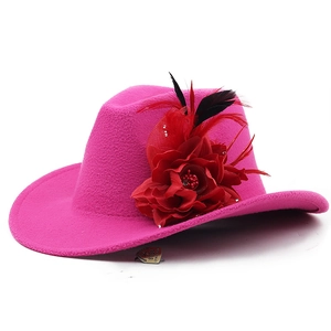 Detail of rose red felt fedora hat featuring fabric flower and feather decorations