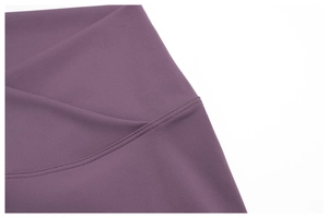 Close-up of purple yoga shorts showing durable flatlock stitching and matte elastic fabric