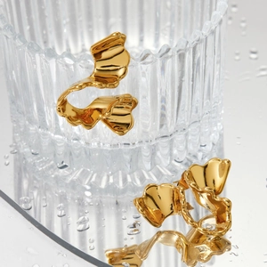 Golden irregular wavy geometric stud earrings with polished mirror finish on glass base