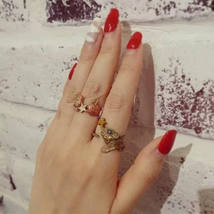 Detail of vintage copper rings with apple, star and bird motifs on a model's hand