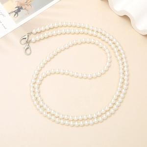 Detailed view of white faux pearl strap with silver lobster clasps for bags and phones