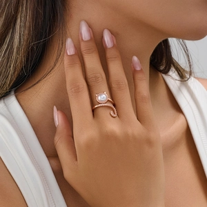 Elegant rose gold cat ring with pearl head and zircon tail worn by a fashion model