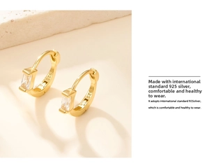 Detailed macro view of S925 sterling silver stamp and rectangular cubic zirconia on gold earring