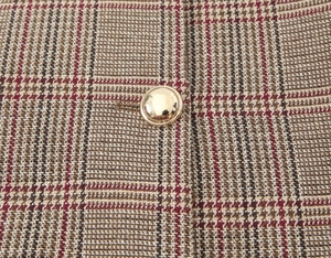 Macro view of houndstooth fabric texture with a golden metallic button detail