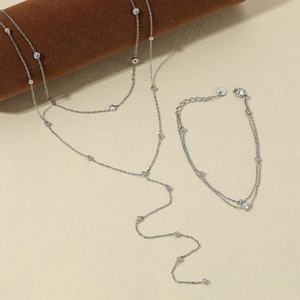 Silver stainless steel jewelry set featuring a layered necklace and zircon bracelet