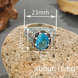 Anello vintage in metallo argento con incisioni elaborate e una grande gemma blu ovale