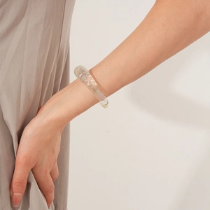Detail of transparent chunky bangle with organic wave texture on model wrist