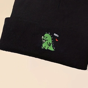 Knitted beanie hat in black with green dinosaur embroidery and Hello text for winter