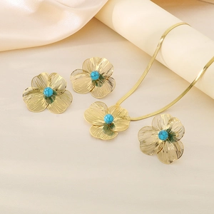 Détail d'une parure vintage dorée avec perles bleues et chaîne à maillons élégante