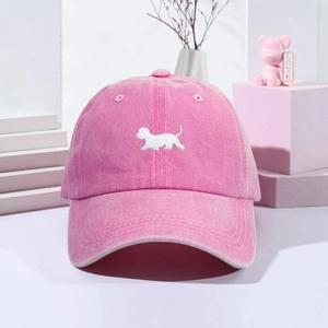 Pink vintage washed baseball cap with white puppy embroidery on a minimalist geometric background