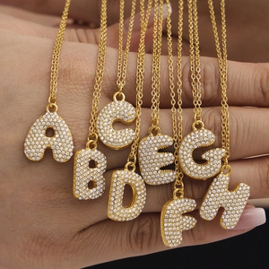 Golden stainless steel initial necklaces featuring crystal-encrusted letters A-H