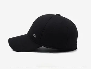 Side view of black wool baseball cap featuring a triangular metal logo badge