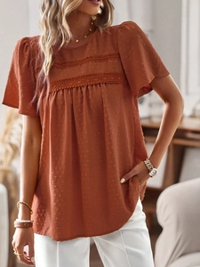 Detail of brick red short sleeve blouse featuring Swiss dot texture and lace decoration