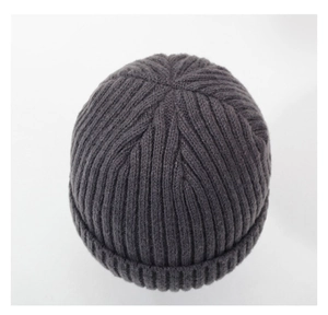 Détail macro du bonnet en maille gris foncé montrant la texture côtelée et le revers