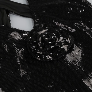 Detailed close-up of 3D rose flower ornament on a black sequin backless dress
