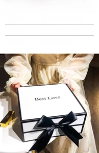 Close-up of white flip-top gift box featuring a black silk bow and Best Love text