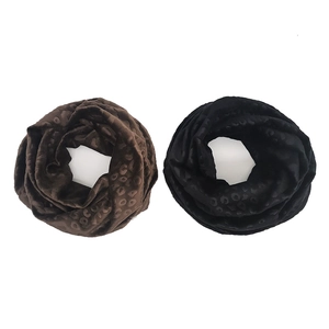 Detail of leopard print plush infinity scarves in brown and black winter fabric