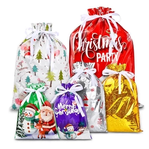 Varietà di sacchetti regalo di Natale con coulisse, motivi festivi e fiocchi di nastro