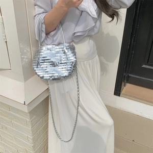 Detail of silver sequined tote bag with glittery metallic texture and fine chain strap