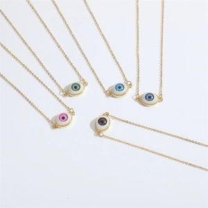 Minimalistische Evil Eye Halsketten in fünf Farben mit vergoldeten Ketten auf weißem Grund