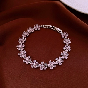 Vue détaillée du bracelet fleur en zircon rose sur fond de soie marron foncé