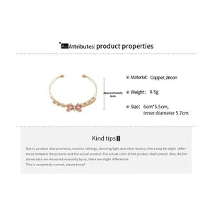 Macro detail of a gold butterfly bracelet with pink zircons and copper material specs