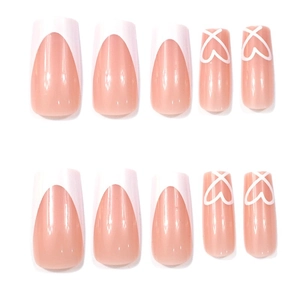 Classic white French tip press-on nails with minimalist heart designs on nude base