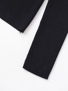Close-up of high-quality black knit fabric showing detailed texture and ribbed cuff finish