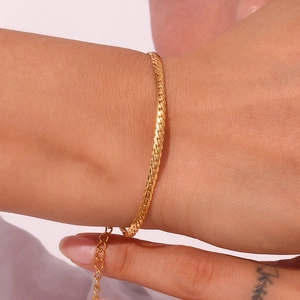 Polished 18K gold plated stainless steel curb chain bracelet on a female wrist