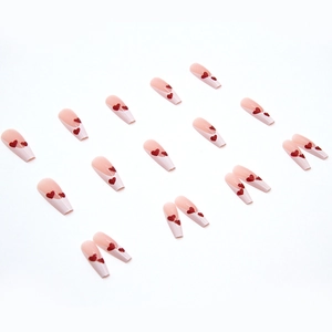 Long ballerina press-on nails with nude pink base, white French tips and red glitter hearts